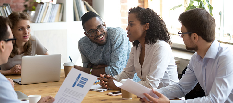 Adults talking in a meeting around a table