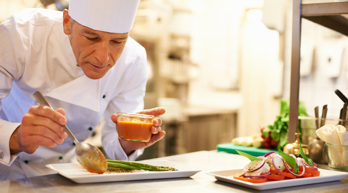 Chef adds sauce to plate