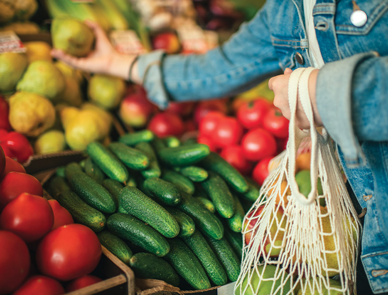 Vegetables and fruit in reusable bag on a farmers market