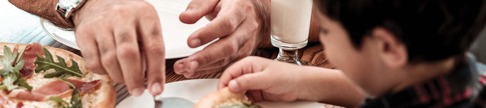 Father and son sharing pizza.