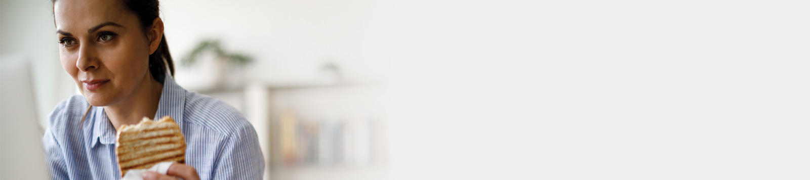 Woman eating lunch while working from home.