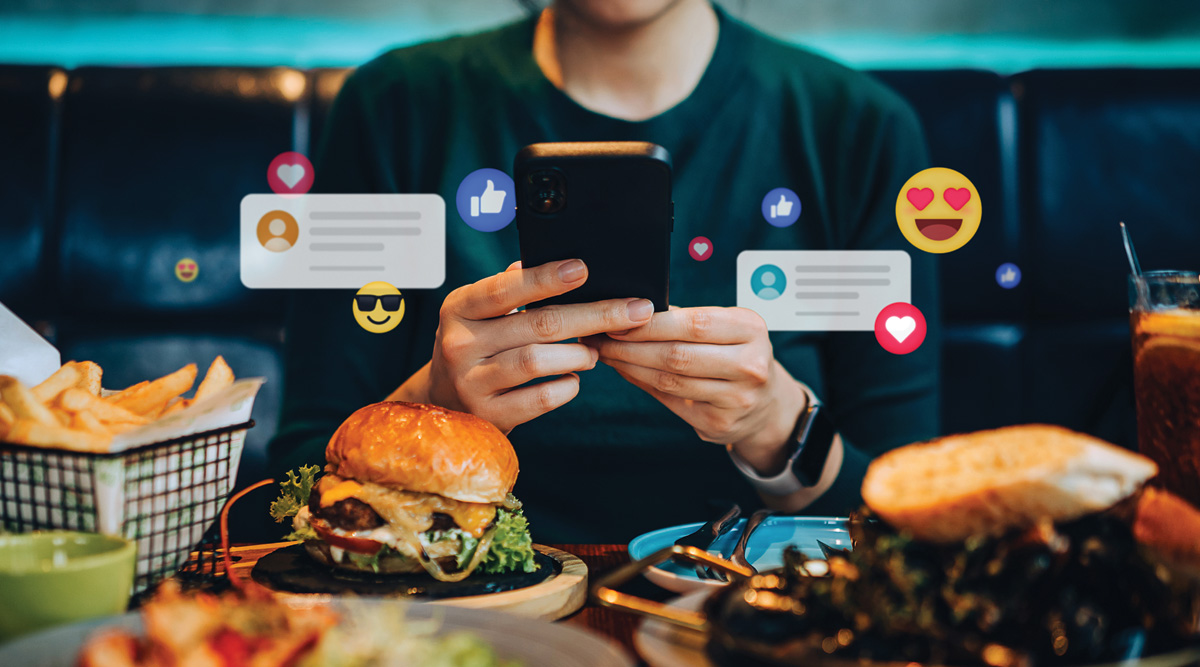 Woman using smartphone on social media app during meal in restaurant.
