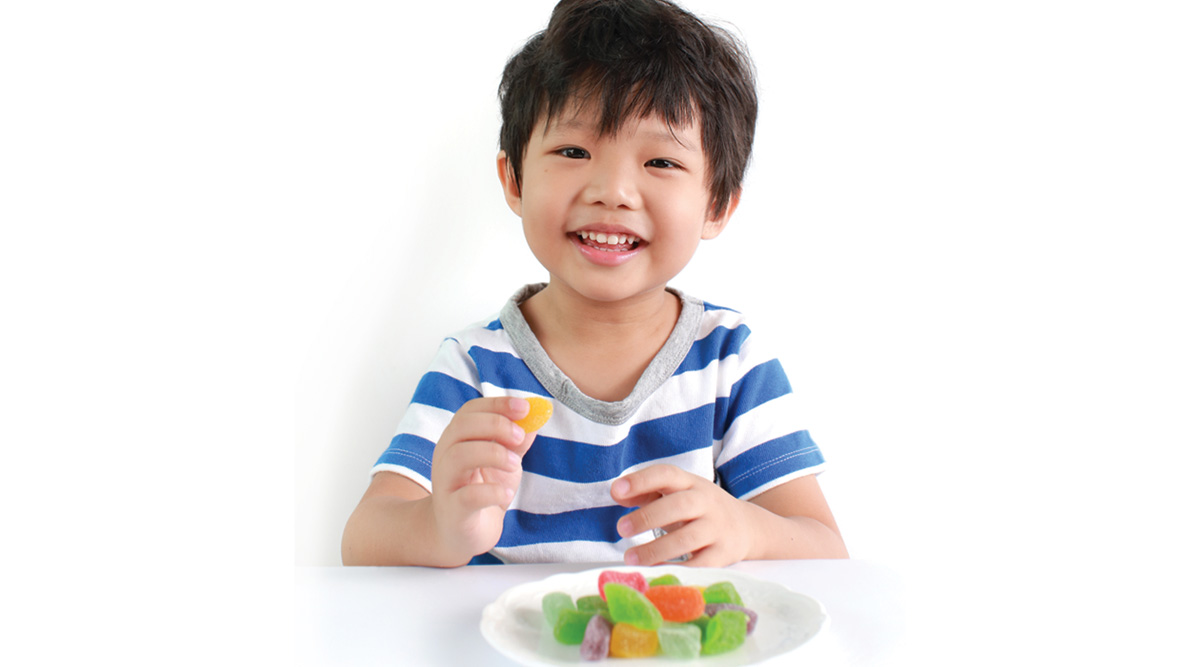 Happy kid eating gummy candy
